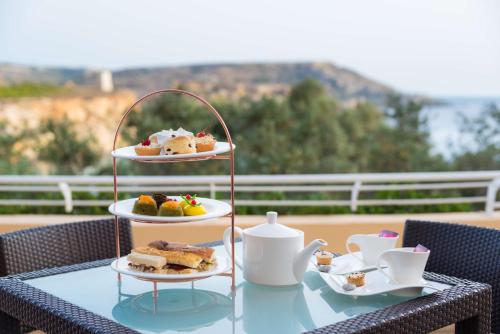 a table with two plates of food on top at Radisson Blu Resort & Spa, Malta Golden Sands in Mellieħa
