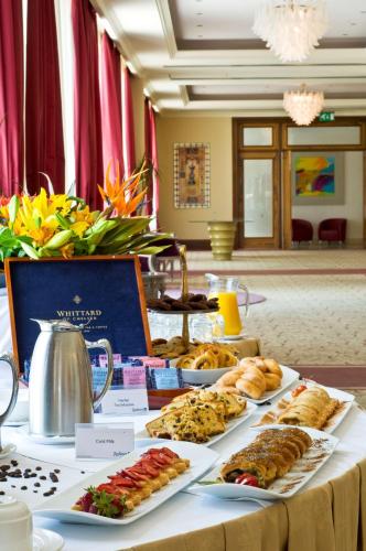 a table with several plates of food on it at Radisson Blu Resort & Spa, Malta Golden Sands in Mellieħa