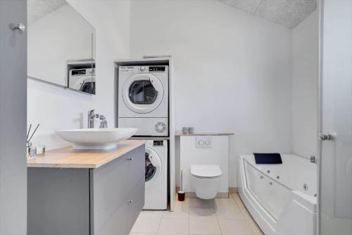 a bathroom with a sink and a washing machine at LK1859-Lokken-Ulstrupvej-19 in Løkken