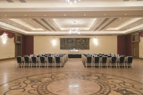 a banquet hall with chairs and a stage in the middle at Radisson Blu Resort & Spa, Malta Golden Sands in Mellieħa