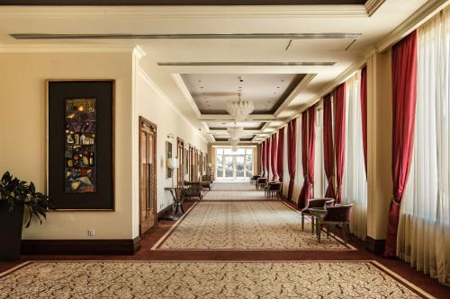 a hallway in a hotel with red curtains at Radisson Blu Resort & Spa, Malta Golden Sands in Mellieħa