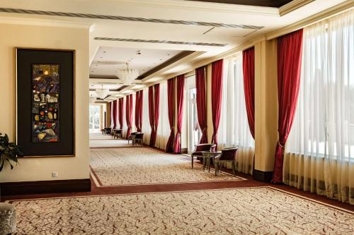 a corridor of a hotel with red curtains and chairs at Radisson Blu Resort & Spa, Malta Golden Sands in Mellieħa