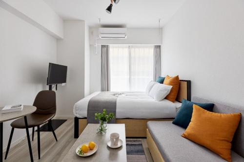 a hotel room with a bed and a couch at The Parkcross Kikukawa in Tokyo