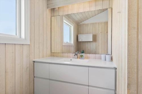 a bathroom with a white sink and a mirror at LK1985-Lokken-Monasvej-24 in Løkken