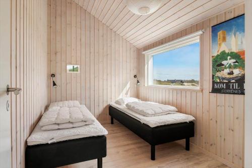 two beds in a room with a window at LK1463-Lokken-Rosavej-11 in Løkken