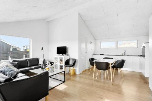 a living room with a couch and a table and chairs at LK1863-Lokken-Ulstrupvej-21 in Løkken