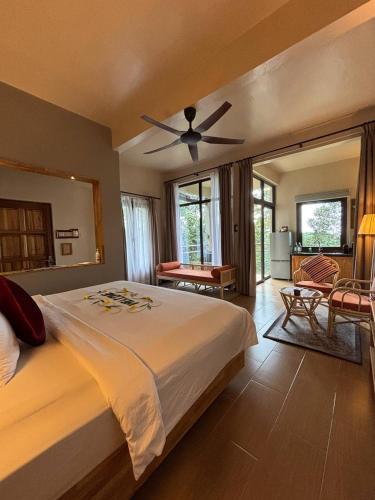 a bedroom with a large bed with a ceiling fan at Ambong Rainforest Retreat in Pantai Cenang