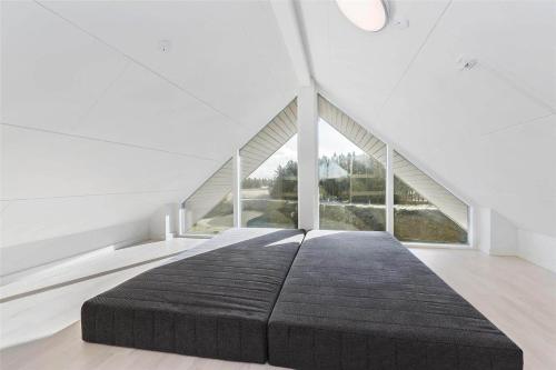 a large bed in a white room with a large window at LK1106-Lokken-Strandparken-32 in Løkken