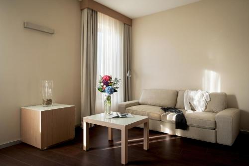a living room with a couch and a table at Hotel Federico II in Iesi