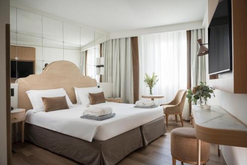 a bedroom with a large white bed in a room at Hotel Mioni Pezzato in Abano Terme
