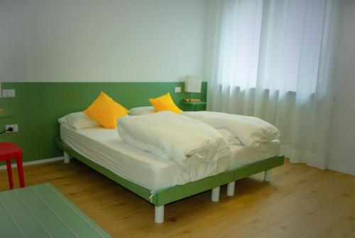 a bed with yellow and white pillows on it at Countryhouse Verso in Rovereto