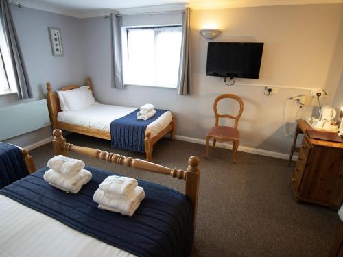 a hotel room with a bed and a tv at The Heath Inn in Leighton Buzzard