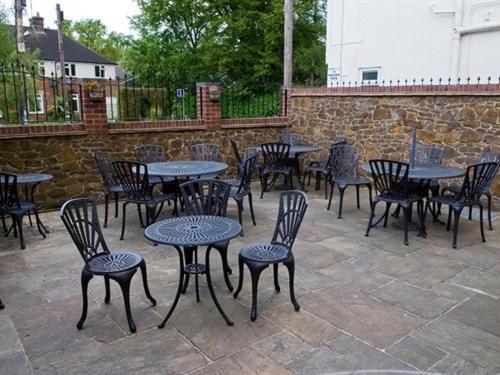 a bunch of tables and chairs with tables and chairs at The Heath Inn in Leighton Buzzard