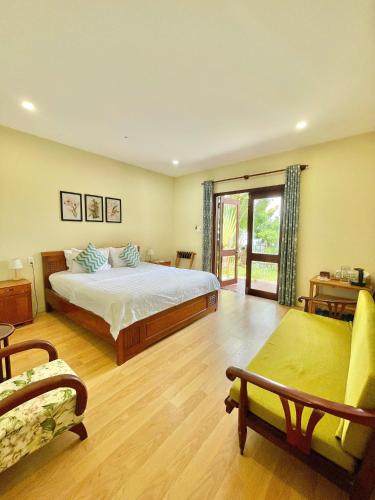 クイニョンにあるHaven Boutique Hotel Quy Nhonの広いベッドルーム(ベッド1台、ソファ付)