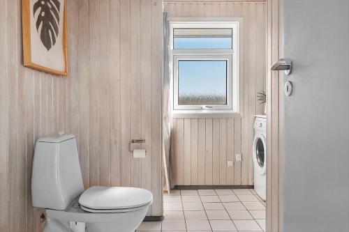 a bathroom with a toilet and a window at LK2129-Lokken-Diget-18 in Løkken