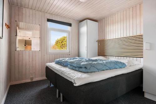 a bedroom with a large bed with a window at LK2129-Lokken-Diget-18 in Løkken