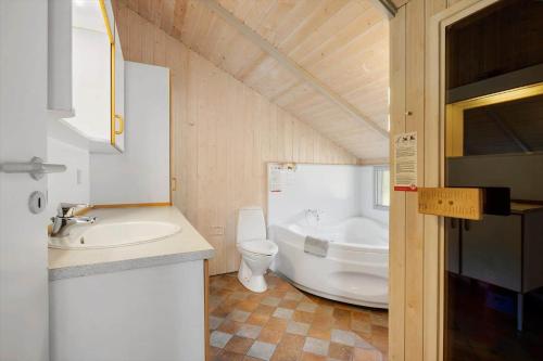 a bathroom with a toilet and a sink and a tub at LK599-Lokken-Stellavej-16 in Løkken