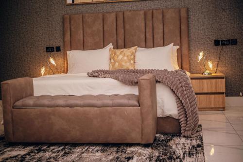 Un dormitorio con una cama grande y un sofá. en FraMMa Homes, en Akure