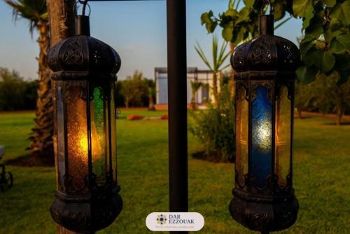 two glass lanterns on a pole in a yard at Dar Ezzouak in Heddad