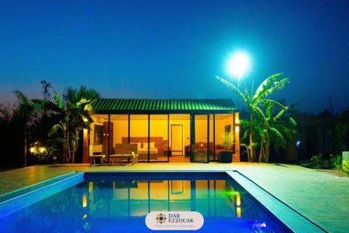 a villa with a swimming pool at night at Dar Ezzouak in Heddad