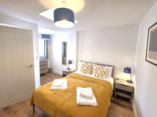 a bedroom with a bed with two towels on it at Modern One Bed Flat at Dawe Luxury Suites - An Entire Apartment near Ely Cathedral & Train Station - The Perfect Gateway to Explore Ely, Cambridge, Norfolk & London - Sleeps up to 4 in Ely