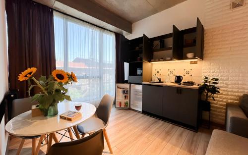 a kitchen and a table with a vase of sunflowers on it at Rooms Apart Hotel by RED in Yerevan