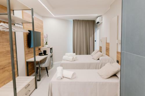 ペスカーラにあるStella D'Oro Roomsのベッド2台と机があるホテルの部屋