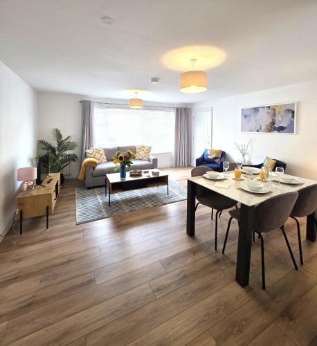 a living room with a table and a couch at Modern One Bed Flat at Dawe Luxury Suites - An Entire Apartment near Ely Cathedral & Train Station - The Perfect Gateway to Explore Ely, Cambridge, Norfolk & London - Sleeps up to 4 in Ely