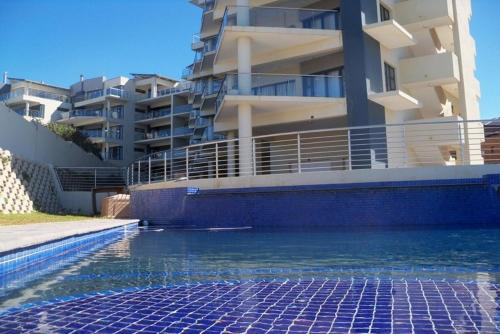 a swimming pool in front of a apartment building at Whale Rock in Margate