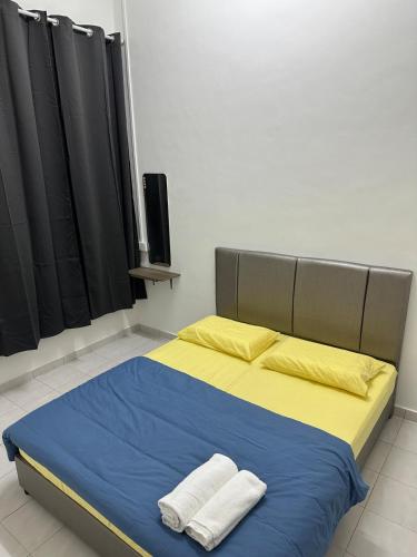 a bedroom with a bed with two towels on it at Aii Minsu in Kluang