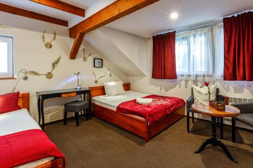 a bedroom with two beds and a desk and a table at Harry nie z tej bajki & Bałtycka44 Apartments in Olsztyn