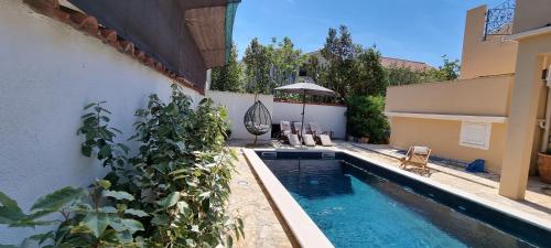 a swimming pool in front of a building with a plant at Apartment 5237-2 in Batalaži