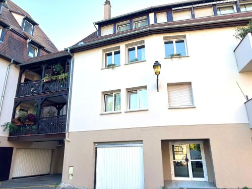 a large white building with a balcony at Une Place A Part in Obernai
