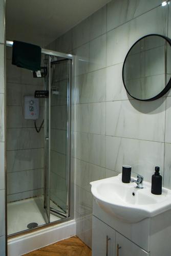 a bathroom with a shower and a sink and a mirror at belgian studio Apt 2 in Huddersfield