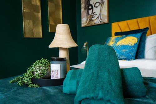 a bedroom with a green couch with a lamp at belgian studio Apt 2 in Huddersfield
