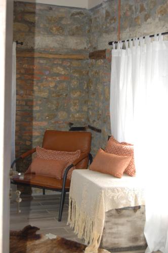 a room with a couch and a chair and a window at Vrachos est 1925 