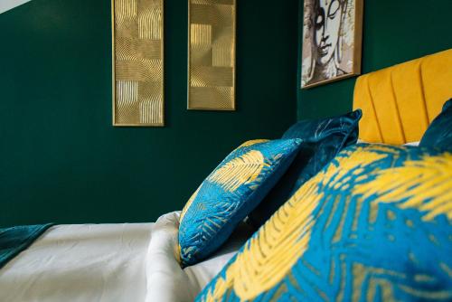 a bed with two blue and yellow pillows on it at belgian studio Apt 2 in Huddersfield