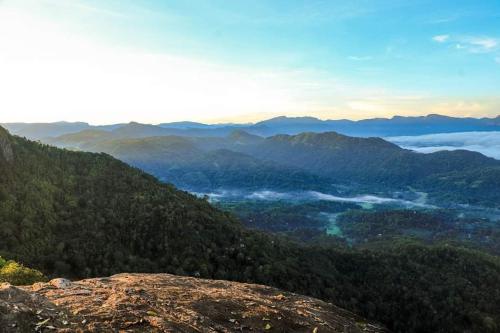 a view of a mountain valley with clouds in the distance at Villa De Sunrise spice garden in Kadugannawa