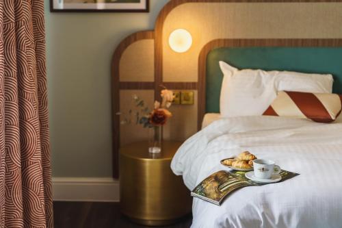 a bed with a tray with a cup of coffee and pastries at Grange Hotel in Grange Over Sands