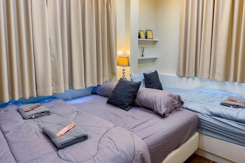 two twin beds in a room with a window at Punsuk Poolvilla in Suan Lang