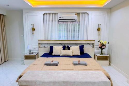 a bedroom with a large bed with blue sheets at Punsuk Poolvilla in Suan Lang