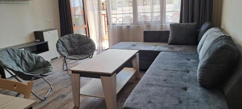 una sala de estar con un sofá y una mesa en Lighthouse GbA 304, en Balchik