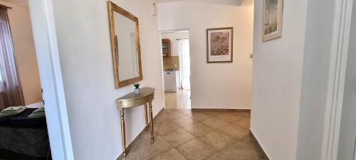 een hal met een wastafel en een spiegel aan een muur bij Apartment 5237-1 in Batalaži