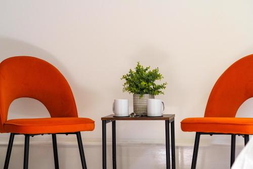 two orange chairs and a table with a plant on it at Private & Peaceful Double Ensuite Rooms in Stapleford in Stapleford