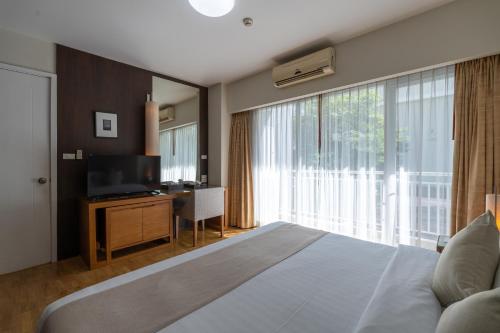 a bedroom with a bed and a tv and a large window at Kantary Hills Hotel, Chiang Mai in Chiang Mai