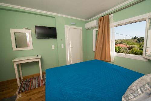 a bedroom with a blue bed and a window at Marianna's and Aristidis' houses in Sívros