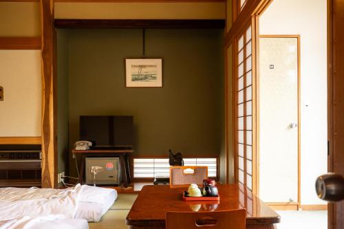 a living room with a bed and a table at Shimaya in Yamanouchi