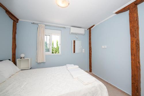 a bedroom with a white bed and a window at Marianna's and Aristidis' houses in Sívros