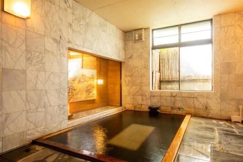 a room with a pool of water in a room with a window at Shimaya in Yamanouchi