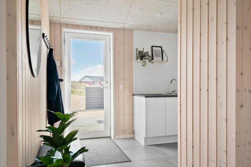 a kitchen with a door leading out to a balcony at 244-Harboore-Knaresbrovej-17 in Harboør